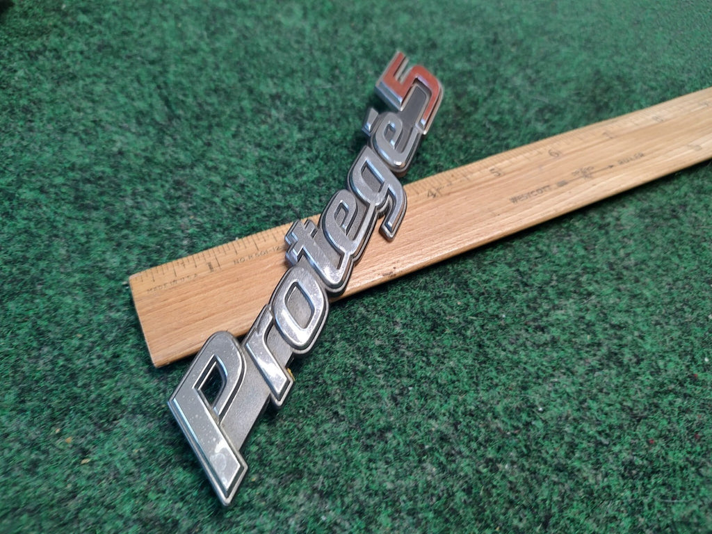 99 00 01 02 03 MAZDA PROTEGE 5 REAR CHROME EMBLEM LOGO BADGE SYMBOL USED OEM 4S4